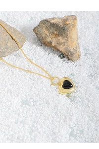 Detail eines Vintage-Herz-Anhängers aus schwarzem Achat an einer goldenen Kette