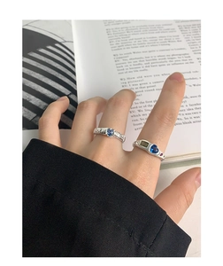 Detail of vintage S925 silver rings with blue heart zircon on an open book