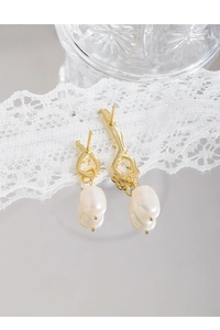 Close-up of liquid metal asymmetrical S925 earrings with baroque pearls on lace