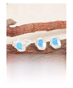 Detail of silver jewelry set with irregular ocean blue opal stones on wood