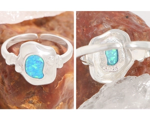 Détail macro du poinçon en argent S925 et de l'opale bleue sur la bague