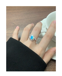 Détail d'une bague en argent S925 au design de métal liquide avec opale bleue