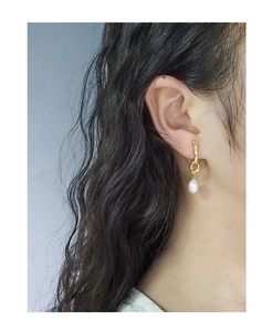 Detail view of liquid metal gold earring with irregular baroque pearl on female model