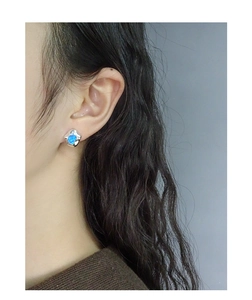 Irregular liquid metal silver earrings with ocean blue opal stone on model's ear