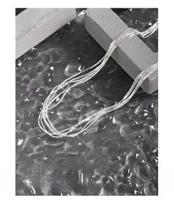 Detail of silver multi-layer layered necklace with polished finish on gray stone