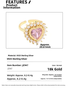 Détail d'une bague coeur avec pierre rose, halo de perles et anneau doré ajustable en argent