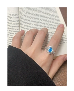 Gros plan d'une bague en argent S925 avec opale bleue portée au doigt