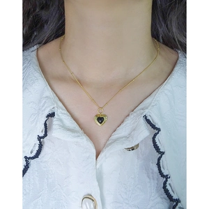 Elegante goldene Herz-Halskette mit schwarzem Achat-Anhänger an einer Perlenkette