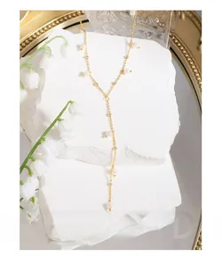 Detailed close-up of a golden Y-shaped pearl necklace with elegant drop chain and fine beads