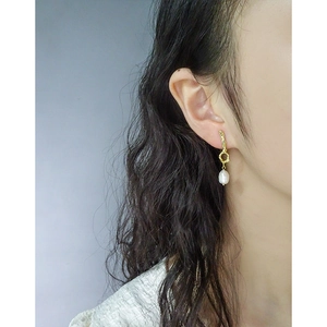 Elegant gold asymmetric liquid metal earrings with baroque pearl on female model
