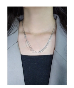 Detail of layered S925 silver necklace on neck with polished multi-strand design