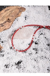 Macro detail of red coral beads with S925 silver spacers on a rustic wooden base