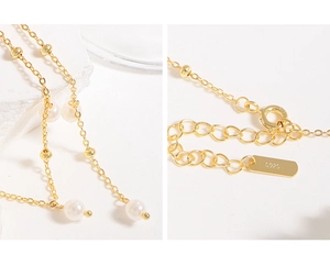 Detailed macro view of S925 sterling silver stamp and adjustable chain on gold Y-necklace