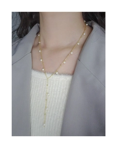 Detailed view of elegant gold Y-shaped pearl lariat necklace worn on a model
