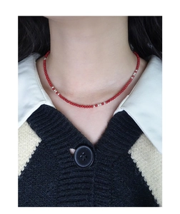 Close-up of minimalist red bead necklace with S925 silver accents on a model's neck