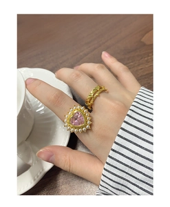 Détail de la bague cœur en zircon rose avec perles et anneau doré texturé empilable