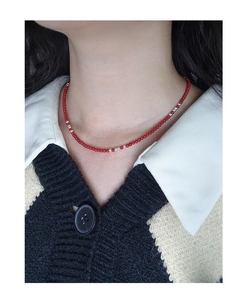 Close-up of minimalist red bead and silver ball choker necklace on female model