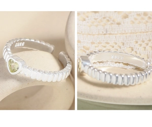 Macro detail of S925 sterling silver ring featuring heart zircon and twisted band textures