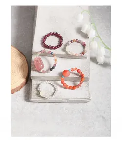 Detail of assorted natural crystal beaded rings including strawberry quartz and amethyst