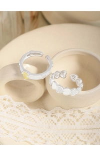 Detail of S925 sterling silver heart rings with yellow zircon and engraved textures