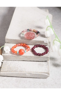 Detailed view of elastic beaded rings with natural strawberry quartz and garnet stones