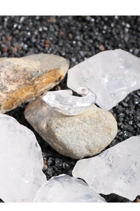Macro shot of silver S925 open ring with irregular lava texture placed on raw grey stone