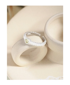Detailed close-up of S925 sterling silver stamp and yellow heart stone on textured ring