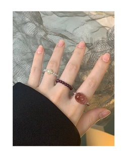 Close-up of three stacked elastic S925 silver rings with natural crystal beads on hand