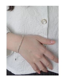 Détail du bracelet chaîne de corde en argent S925 sur poignet avec texture de chemise