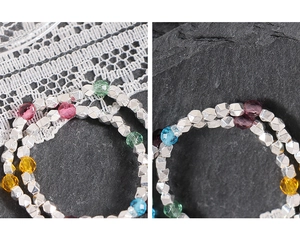Macro shot of silver faceted beads and colorful transparent crystals on a lace background