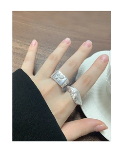 Detail of silver S925 butterfly embossed ring and irregular textured band on model