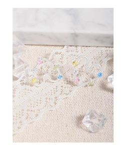 Close-up of S925 silver heart stud earrings with colorful zircon stones on marble