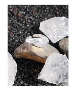 Macro detail of silver S925 open ring with lava texture on dark mineral stones