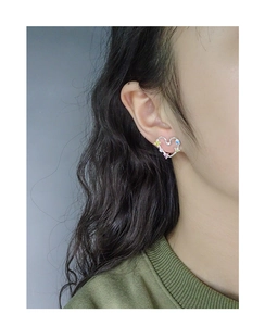 Close-up of rainbow zircon hollow heart earrings worn by a model in silver S925 finish