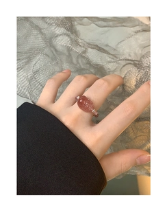Detailed shot of pink strawberry quartz beaded ring with cute animal charm on finger