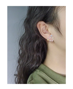 Detail of S925 silver heart earring with colorful zircon stones on model's ear