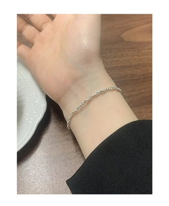 Détail d'un bracelet minimaliste en argent sterling S925 avec perles torsadées au poignet