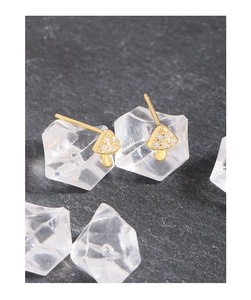 Detailed close-up of tiny mushroom stud earrings with clear zircon stones on crystals