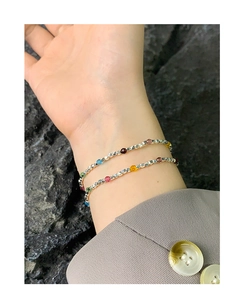 Macro view of multi-color bead and S925 silver layered bracelet on a model wrist