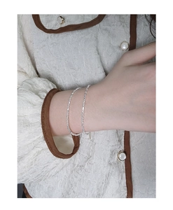 Close-up of a minimalist S925 sterling silver fine bead bracelet on a model wrist