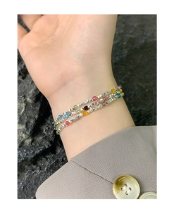 Close-up of triple-layered silver bead bracelet with colorful multifaceted gemstones