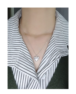 Close-up of S925 silver heart necklace with starburst engraving worn on neck