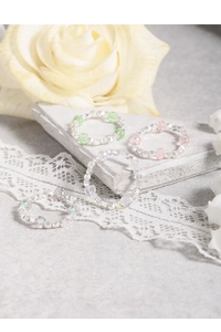 Dettaglio di quattro anelli di perline fatti a mano con sfaccettature argento e cristalli