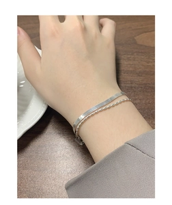 Nahaufnahme des zweilagigen S925-Silberarmbands mit Schlangenkette und Perlendetail