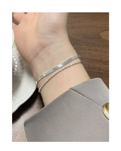 Detail eines S925 Sterlingsilber Doppelarmbands mit Schlangen- und Perlenkette am Handgelenk