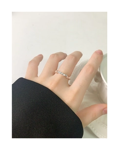 Dettaglio dell'anello in argento S925 con perle metalliche e cristalli rosa sulla mano