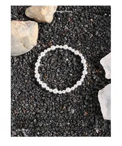 Detailed view of S925 sterling silver beads on a textured natural stone background