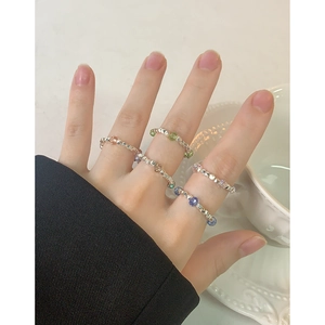 Set di cinque anelli in argento S925 con perline e ciondoli in cristallo colorato sulla mano