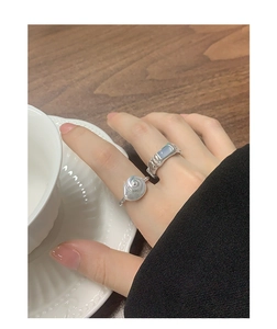 Detail of S925 silver ring set with spiral design and blue agate gemstone on a hand