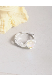 Macro detail of S925 silver ring featuring an iridescent moonstone in a minimalist claw setting